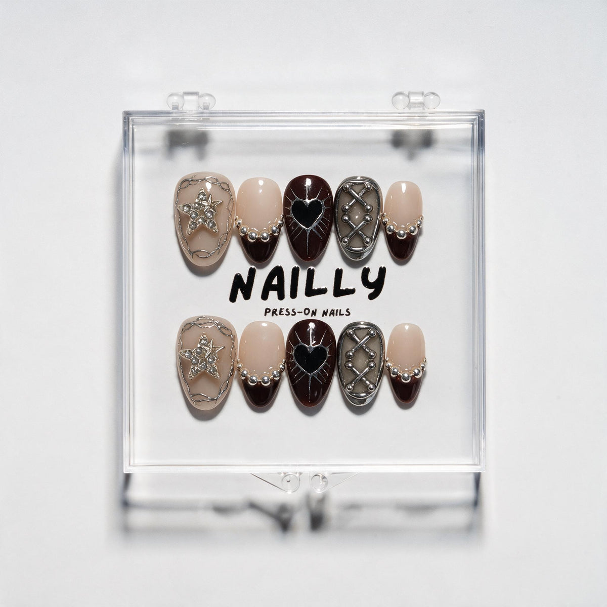 Last Night of Winter short almond press-on nails in burgundy, black and blush nude with silver stars, hearts and bead-chain details
